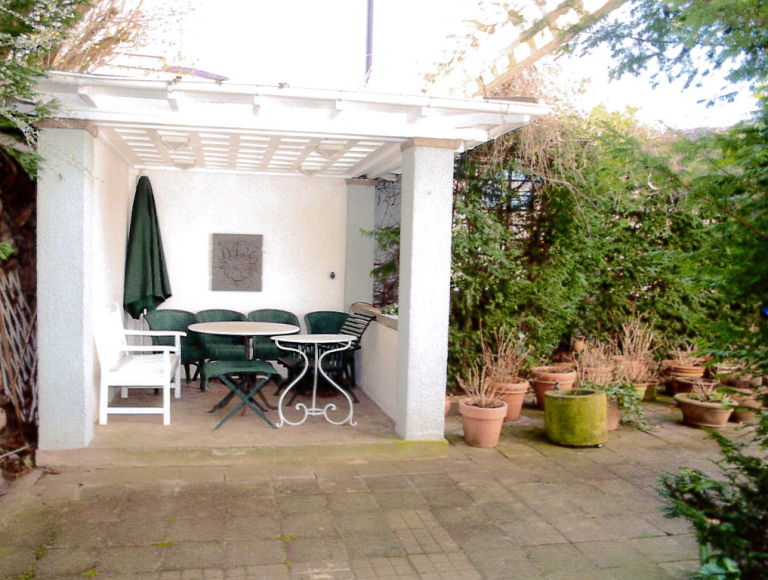 Über das großzügige, ineinandergehende Wohn-/Esszimmer gelangt man über eine großzügige Terrasse mit idyllischer Gartenl